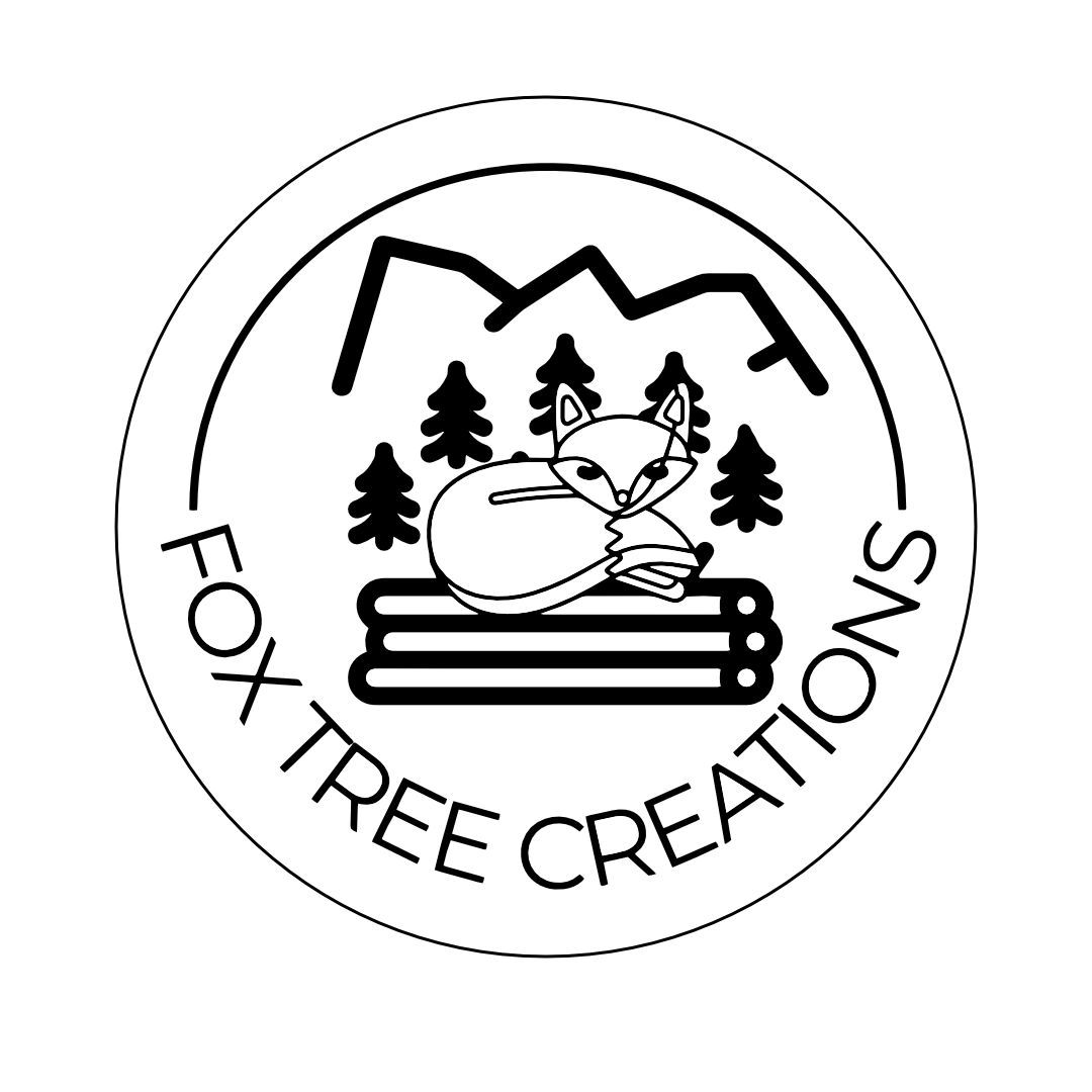 Fox Tree Creations logo with a fox lying on logs in front of trees and mountains custom laser-engraved gifts fee