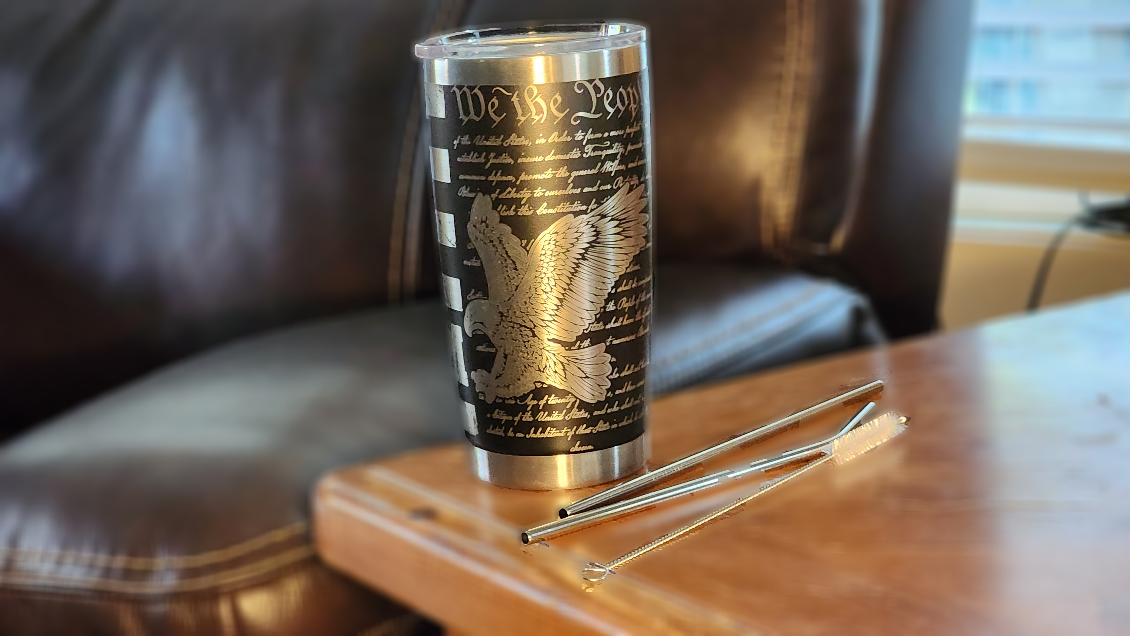 Custom engraved freedom 20oz tumbler featuring an eagle design and words of patriotism on a wooden table