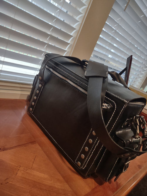 Custom leather messenger bag by Fox Tree Creations with distinctive stitching and metallic accents