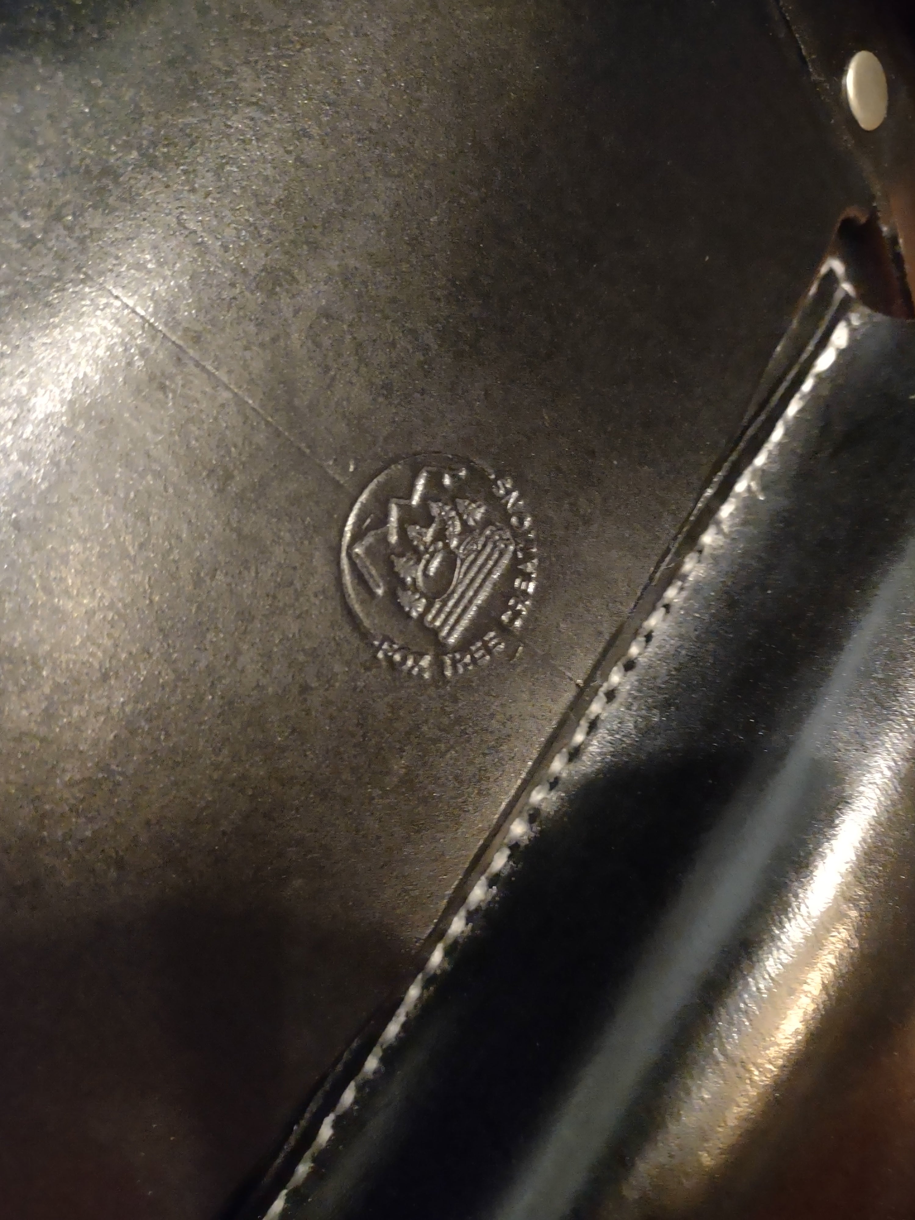 Close-up of the logo on a custom leather messenger bag by Fox Tree Creations, showcasing fine craftsmanship