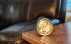 Personalized engraved 20oz tumbler resting on a wooden table near a dark leather couch