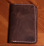 Fox Tree Creations full grain leather field notes cover in dark brown with white stitching on wooden surface
