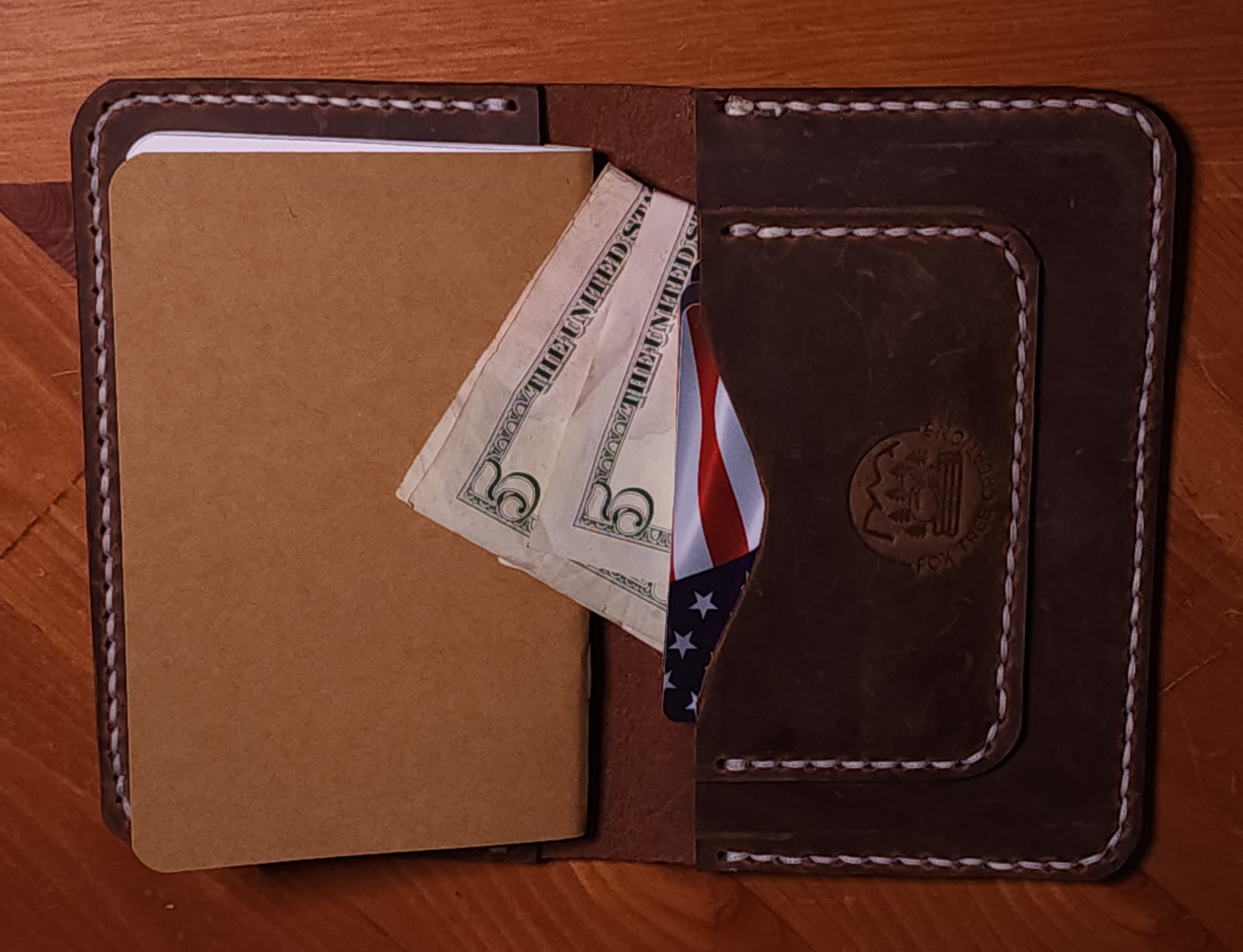 Fox Tree Creations full grain leather field notes cover holding notebook, cash, and cards in dark brown leather