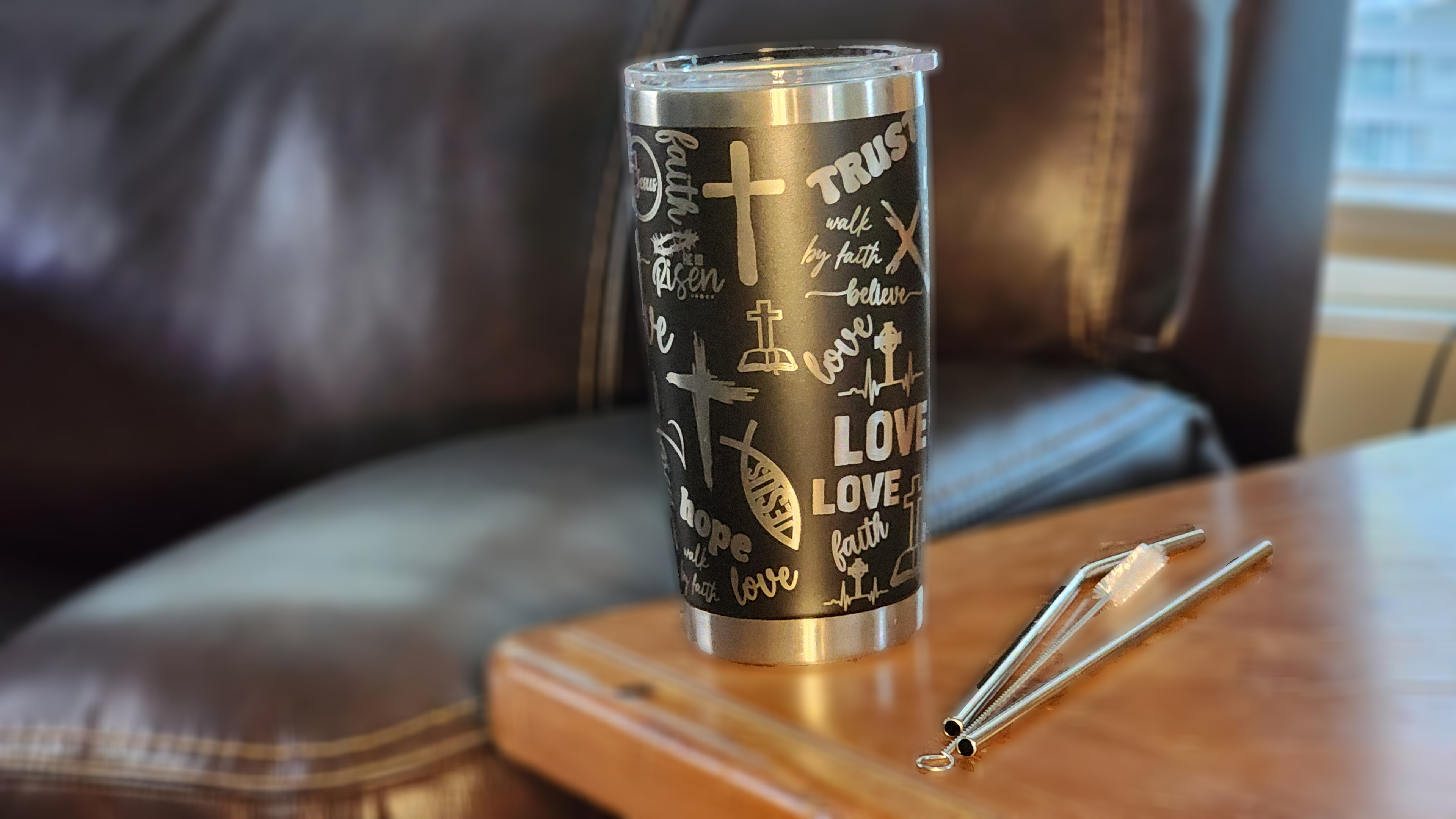 Black laser engraved faith 20oz tumbler with inspirational designs on a wooden table