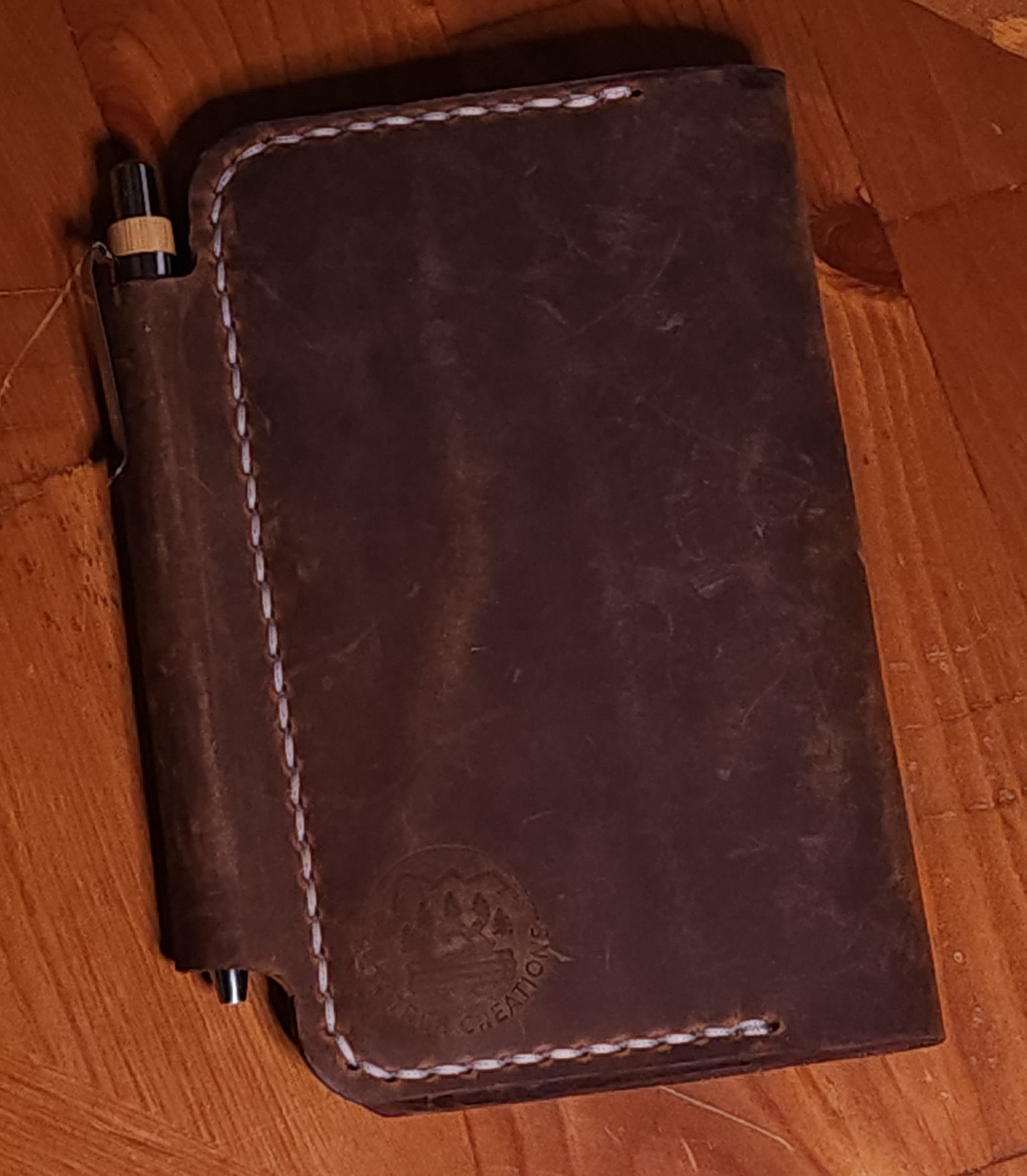 Full grain leather field notes cover in dark brown with white stitching and pen holder by Fox Tree Creations