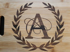 Personalized monogram cutting board with elegant A design surrounded by a decorative laurel wreath