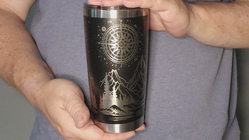 Video showing Custom laser engraved wanderer 20oz tumbler featuring mountain and "Not All Who Wander Are Lost" motto design on a sleek black background