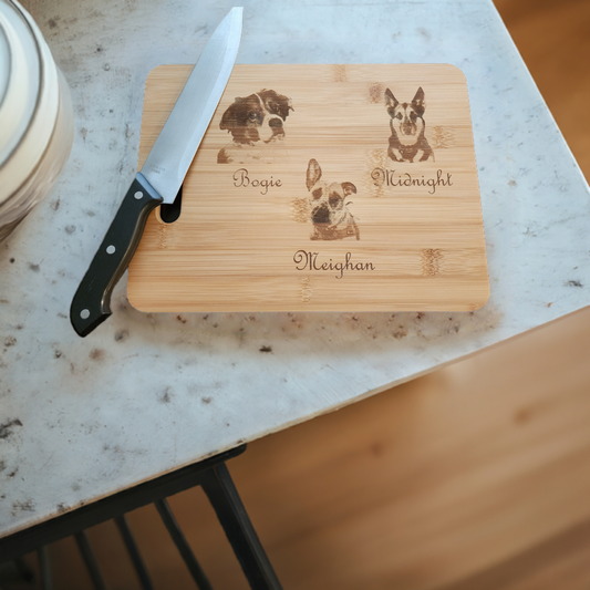 Unique picture cutting board by Fox Tree Creations featuring engraved pet names and a knife on a marble surface