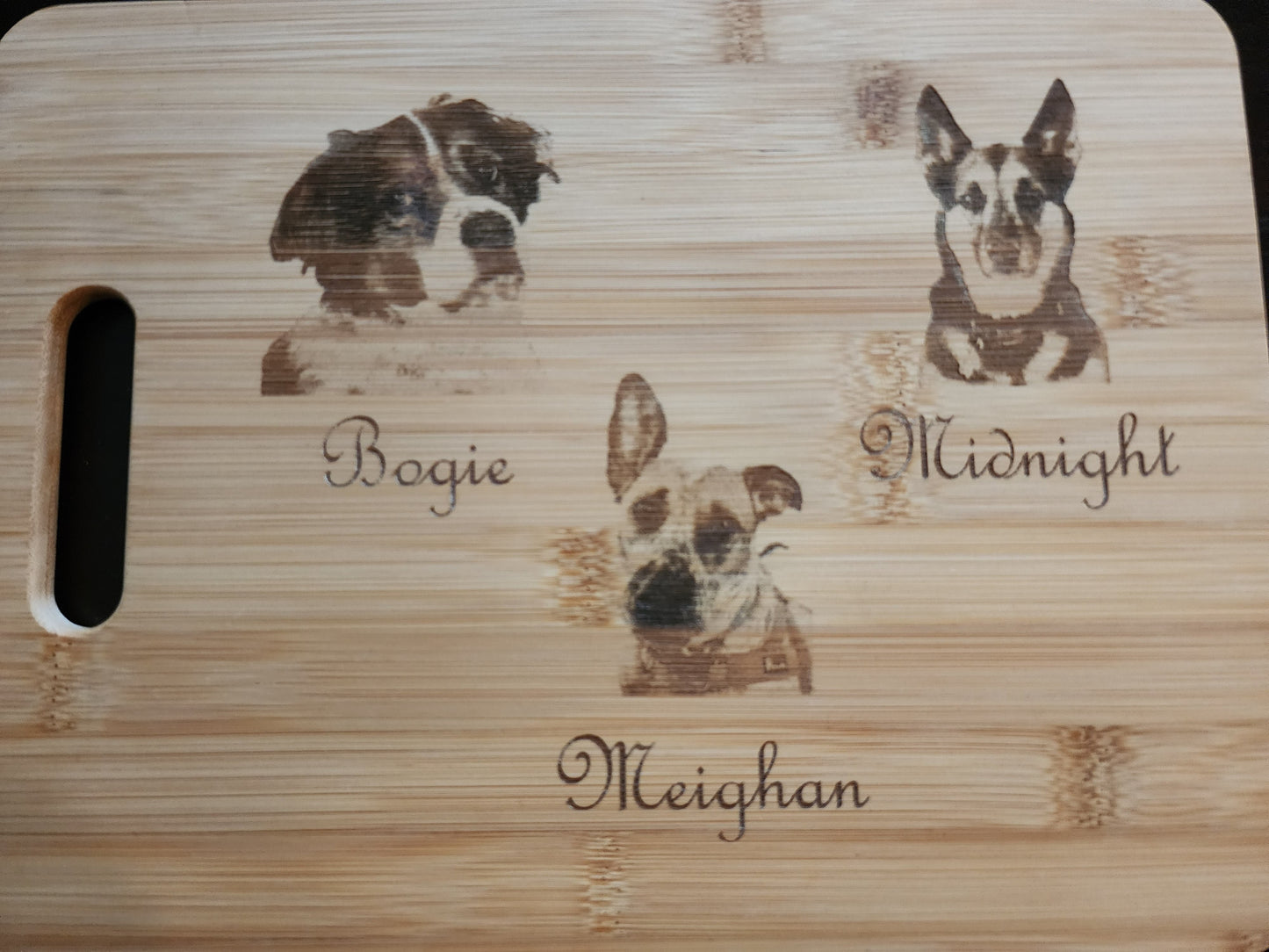 Unique picture cutting board featuring custom pet engravings of dogs with names Bogie, Midnight, and Meighan