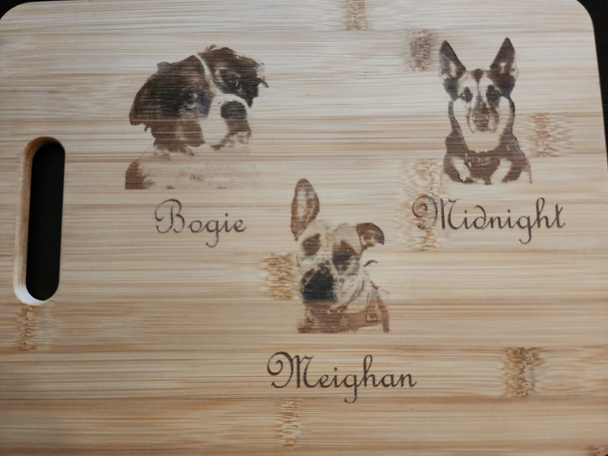 Unique picture cutting board featuring custom pet engravings of dogs with names Bogie, Midnight, and Meighan
