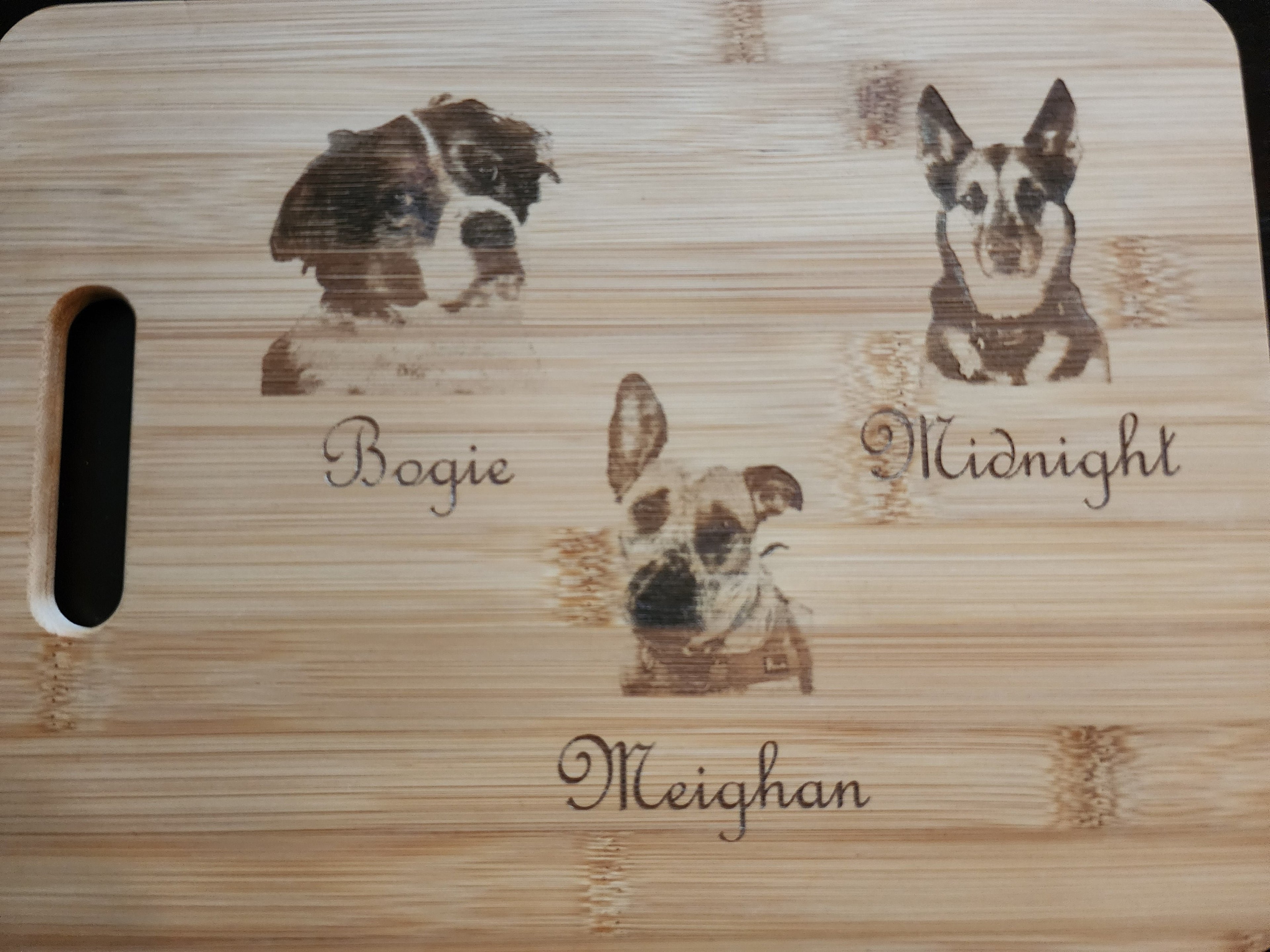 Unique picture cutting board featuring custom pet engravings of dogs with names Bogie, Midnight, and Meighan